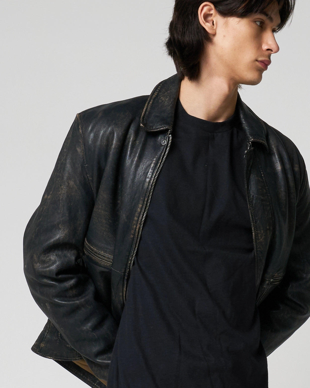 Image shows a man putting his arms behind his back to show how the soft texture of the leather moves.