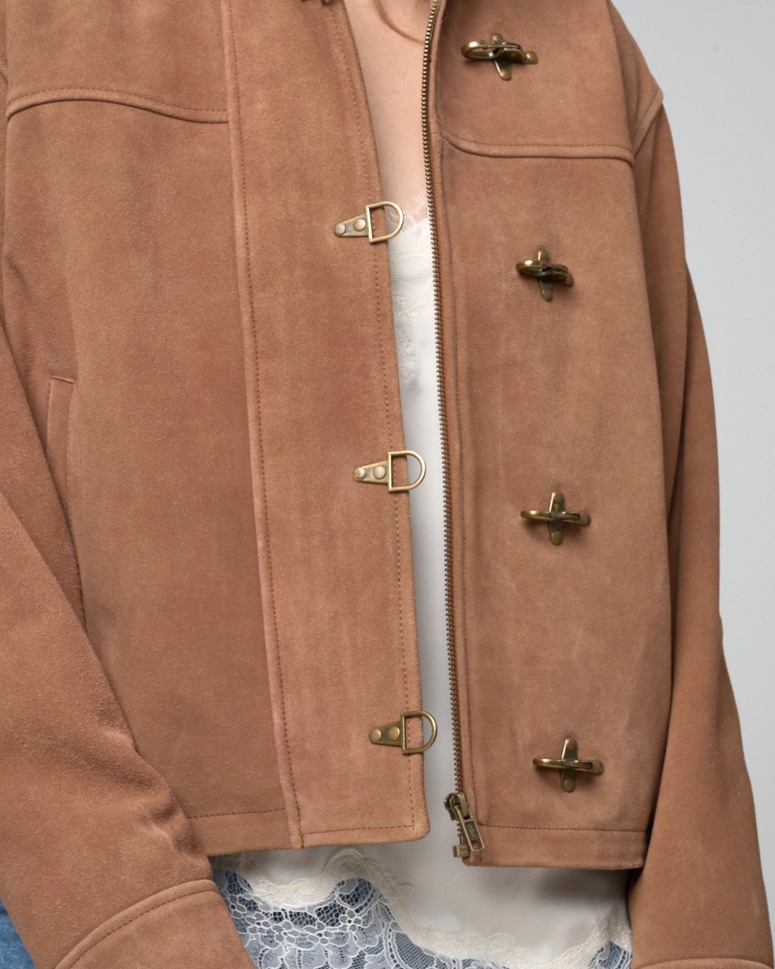 Detail image focusing on the metal fireman clasps, which function as 'hook and eye' fastenings over the central zipline.
