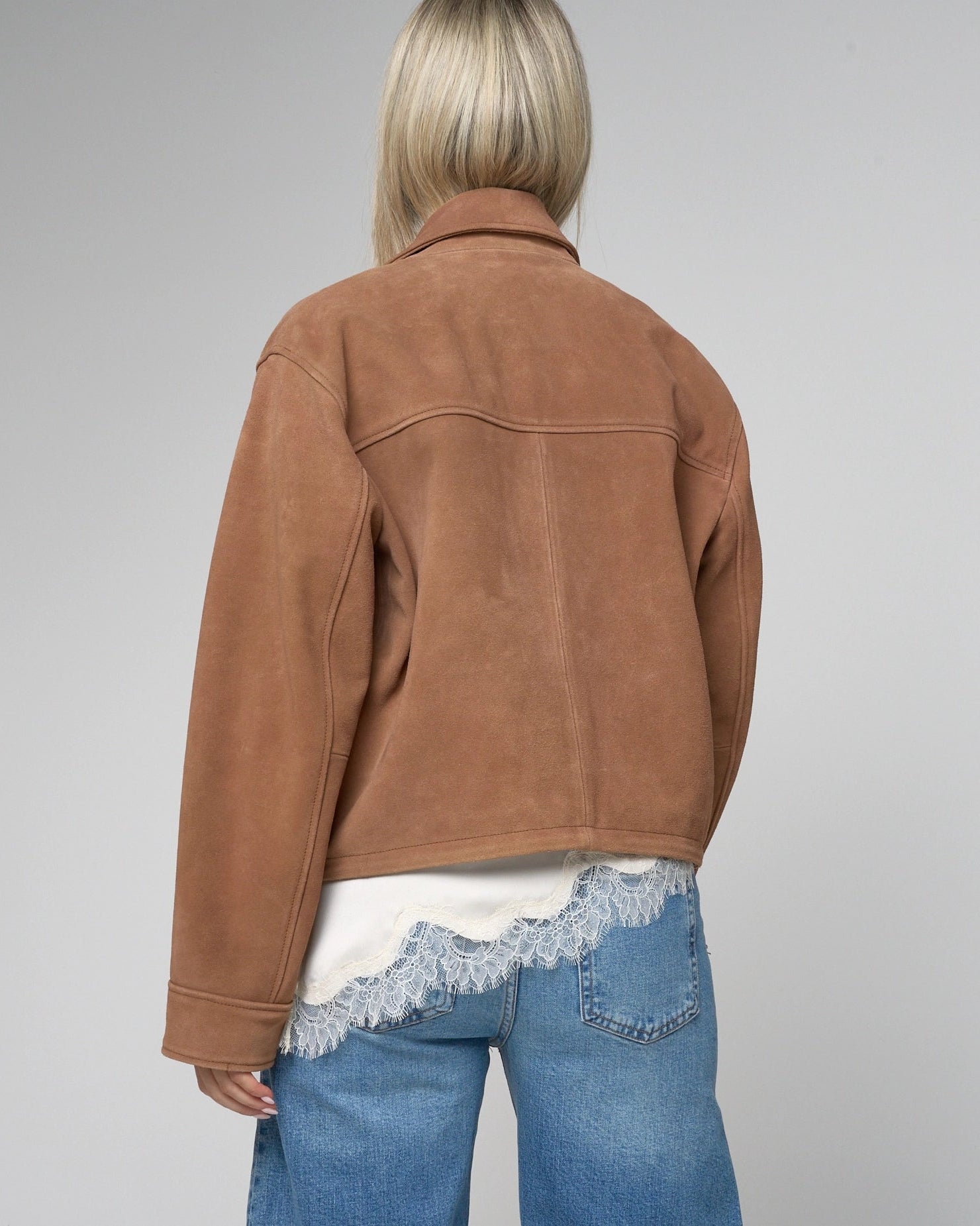 Back of tan suede jacket by barneys Originals. Jacket has a vertical seem and a central horizontal seemline. 