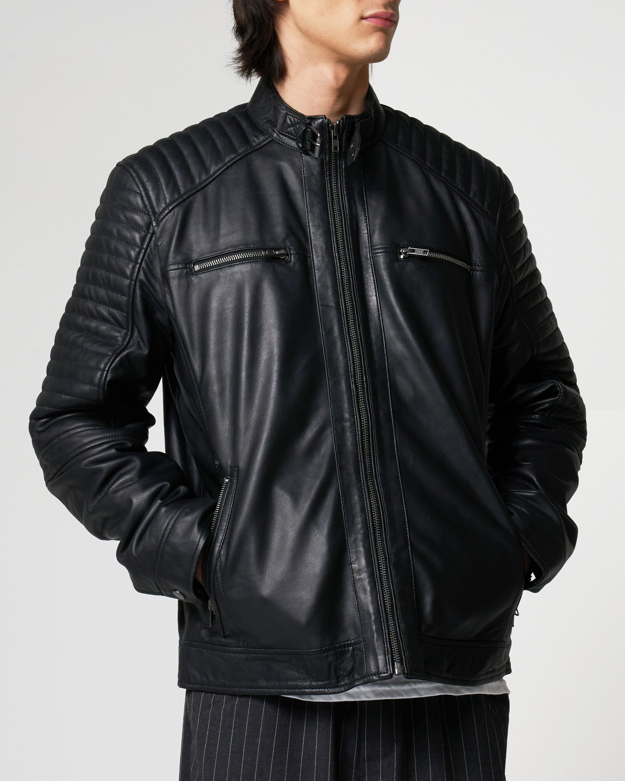 Front facing image of a man wearing the real leather racer jacket. There's a central ziplike, two zipped pockets on the upper chest and ribbed detailing on the shoulders and sleeves.