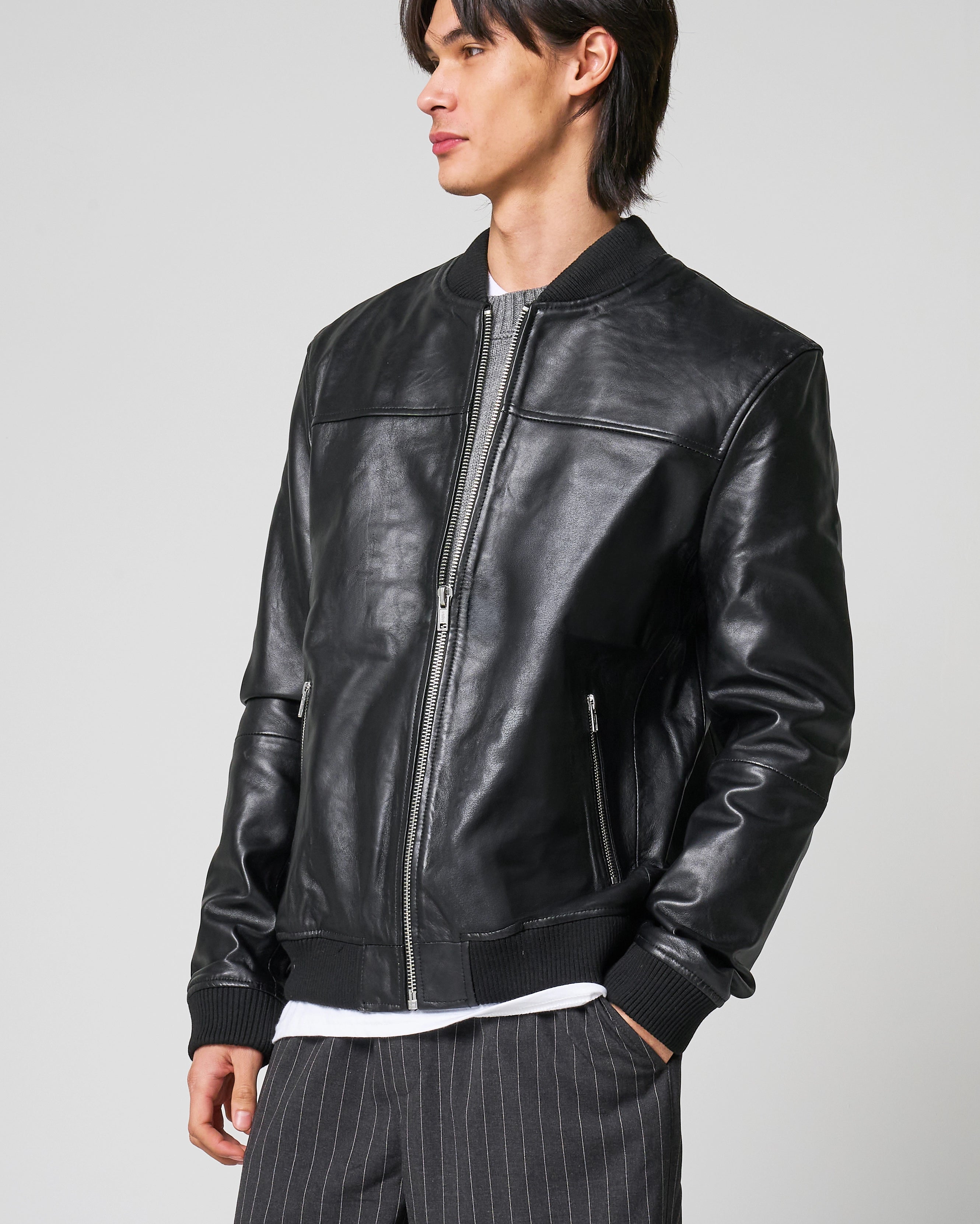 Front of real leather bomber jacket by Barneys Originals, as worn by a male model. The jacket is black in colour with smooth sheep leather.
