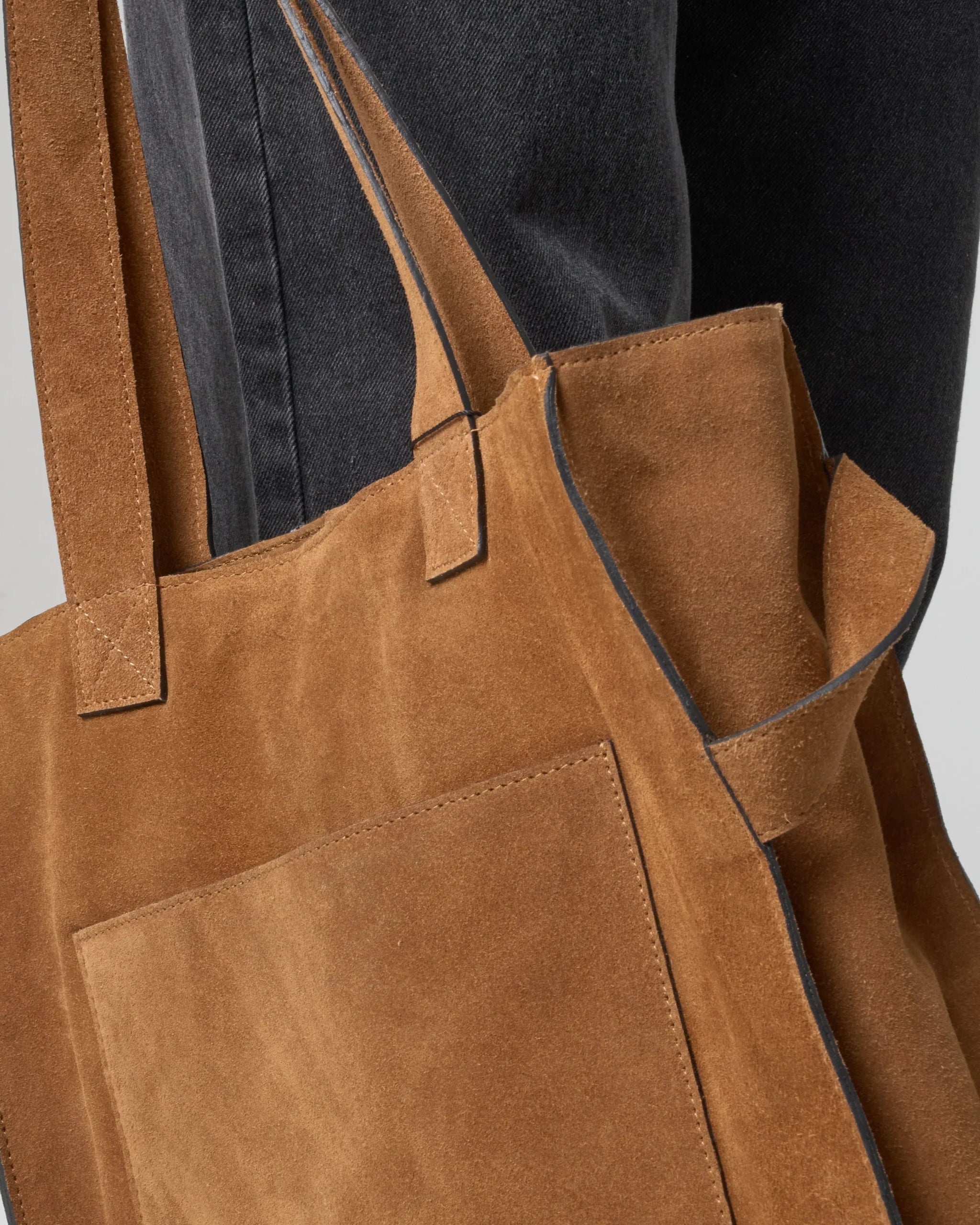 Detail shot of tan suede bag to display the contrasting painted edge.