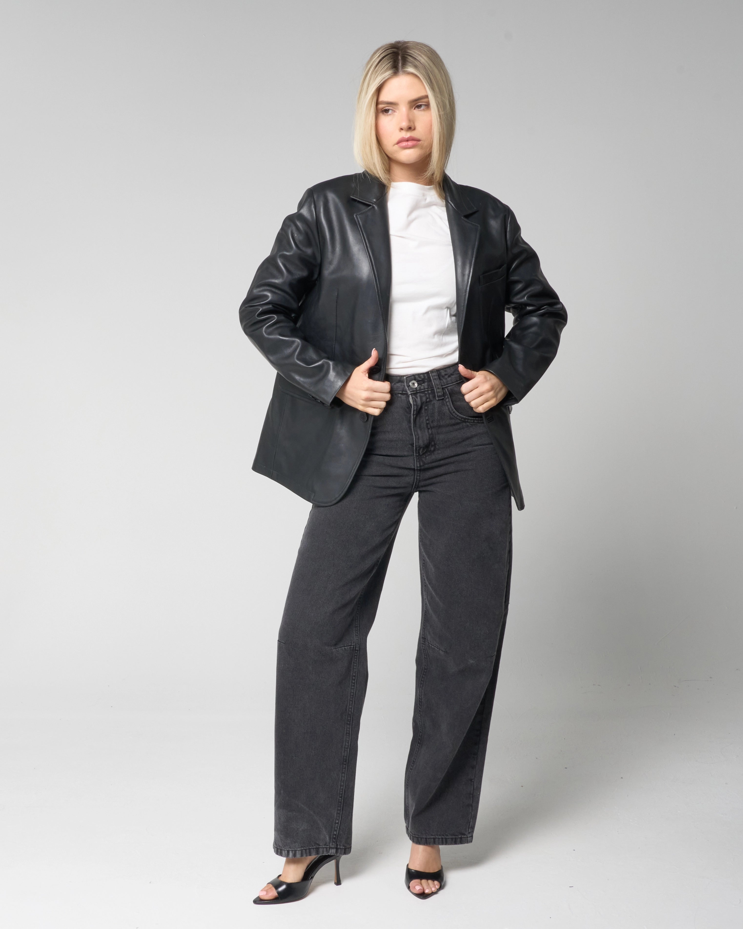 Full outfit shot showing how to style the Barneys Originals real leather blazer jacket. The woman wears it with a white shirt, wide leg black jeans and open toe heels.