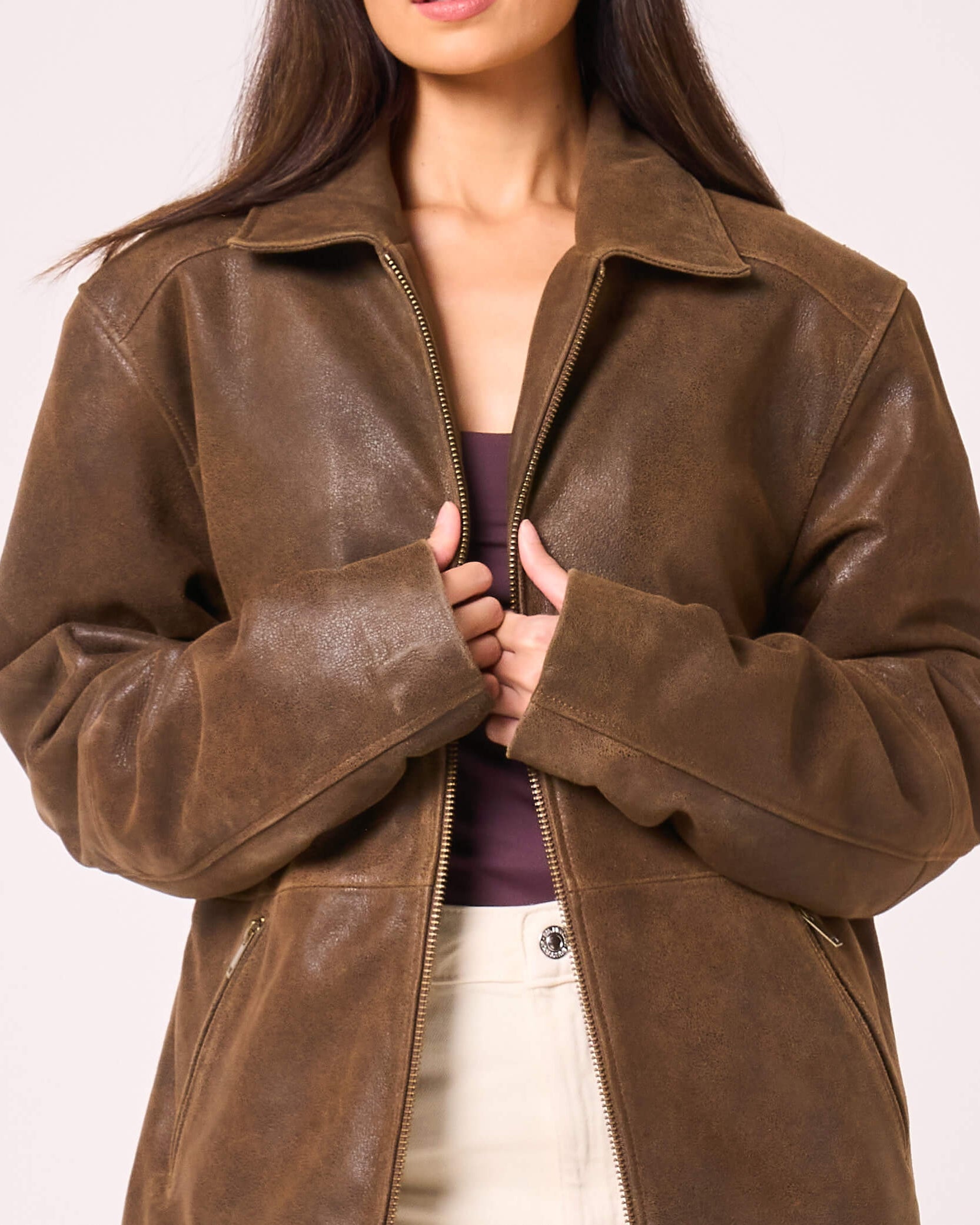 Up close detail of jacket as worn by woman, showing the rough texture of the washed goat leather.