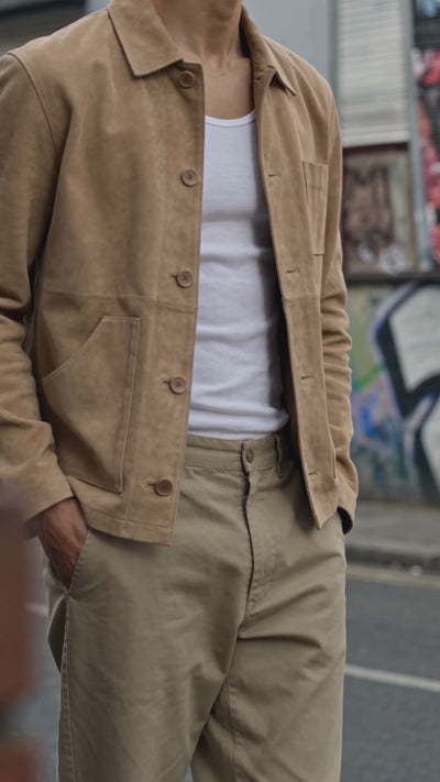 Video footage shot on the streets of Manchester showing close up detail of a man wearing a beige real suede chore jacket.