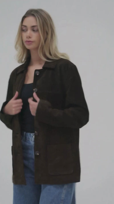 Image shows a blond woman styling the brown suede jacket in a white studio.